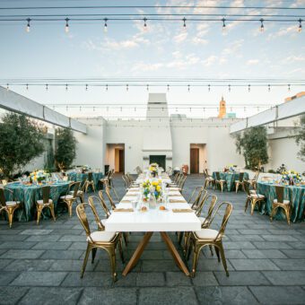 rooftoop decorated with string lights and green and white decorated rectangle tables