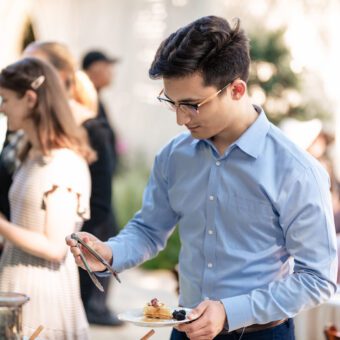 Man in blue shirt getting food from buffet