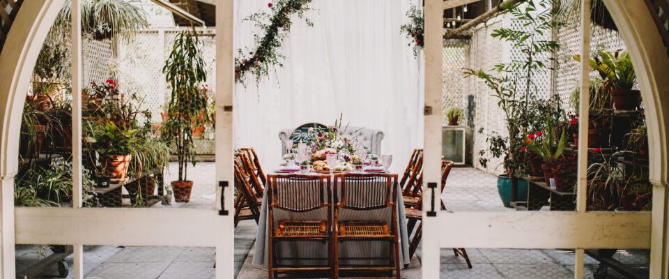 table outside on backyard patio with large windows and hanging white cloth