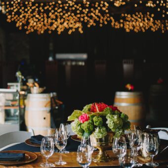 gold and black table setting with twinkling lights in background